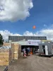 Viering van het hoogste punt van de nieuwe sporthal van middelbare school OBC Bemmel, met bouwvakkers op de bouwplaats, omringd door steigers en bouwmaterialen.